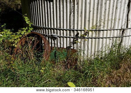 Bottom Rings Of A Concrete Stave Silo Surrounded By Junk And Long Grass