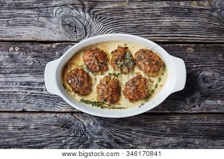 Rabbit Ballotine In Creamy Mustard Sauce With Herbs And Spices In A Baking Dish On A Rustic Wooden T