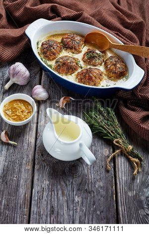 Rabbit Ballotine In A Creamy Mustard Sauce With Herbs And Spices In A Baking Dish On A Rustic Wooden