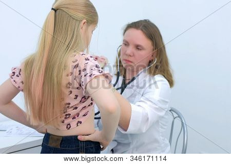 Doctor And Patient On Preventive Examination. Pediatrician Woman Listening To Heartbeat Heart And Lu