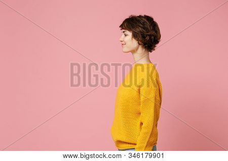Side View Of Smiling Young Brunette Woman Girl In Yellow Sweater Posing Isolated On Pink Wall Backgr