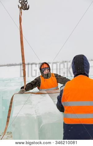 Slinger In Orange Helmet On Shipment Of Ice Blocks