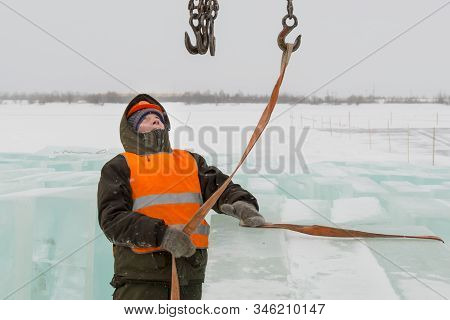 Slinger In Orange Helmet On Shipment Of Ice Blocks