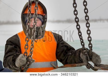 Slinger In Orange Helmet On Shipment Of Ice Blocks