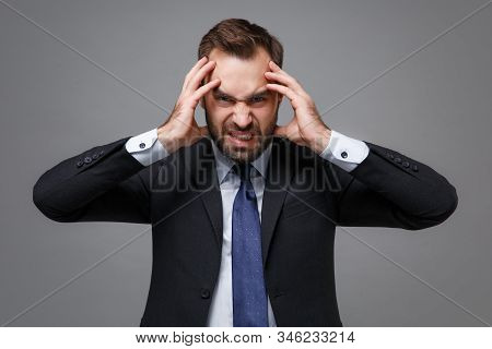 Angry Dissatisfied Young Bearded Business Man In Classic Black Suit Shirt Tie Posing Isolated On Gre
