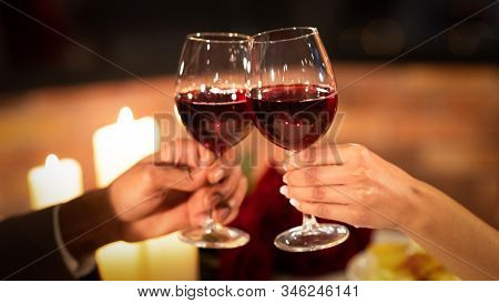 Cheers To Love. Unrecognizable Couple Clinking Red Wine Glasses Having Romantic Date In Fancy Restau