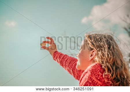 Beautiful Blonde Girl Holding Heart Shaped Stone In Hands, Blue Sky In Background. Rockhounding Disp