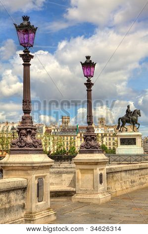 Vertical oriented image of traditional parisian lamppost on famous Pont Neuf bridge in Paris, France.
