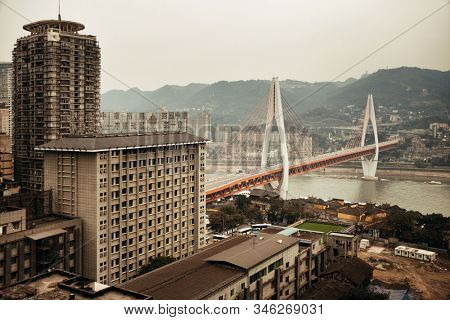 CHONGQING, CHINA â MARCH 13: Dongshuimen Bridge with urban buildings on March 13, 2018 in Chongqing. With 17M population, it is the most populous Chinese municipality.
