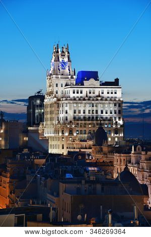 MADRID, SPAIN - MAY 13, 2018: Telefonica Building rise above historical buildings at dusk on Gran Via business district.