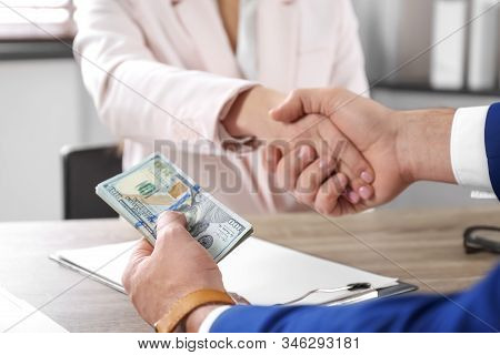 Man Shaking Hands With Woman And Offering Bribe At Table, Closeup