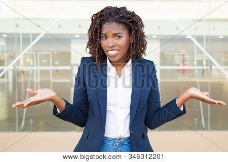 Doubtful Young Businesswoman Looking At Camera. Portrait Of Uncertain African American Businesswoman