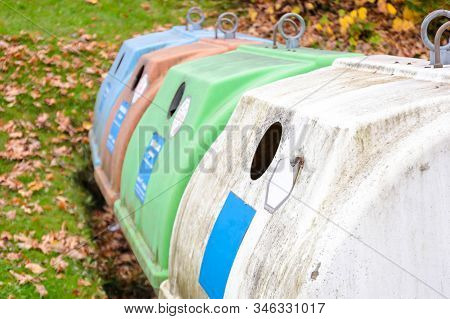 Row Of Old White, Green And Colorful Trash Bin In The Community In Germany, Europe