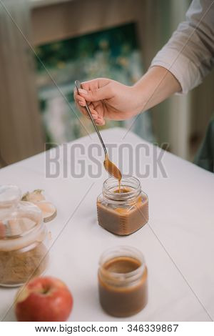 Homemade Salty Brown Liquid Caramel. Homemade Soft Caramel Made From Sugar On A Background Of Apples