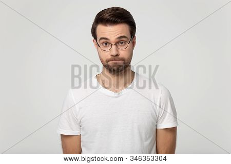 Millennial Dissatisfied Serious Bearded Man In Eyeglasses Squeezing Lips.