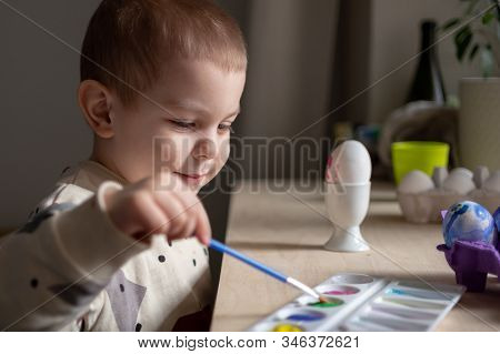 Toddler Boy Painting Easter Eggs Preparing For Holidays. Easter Tradition