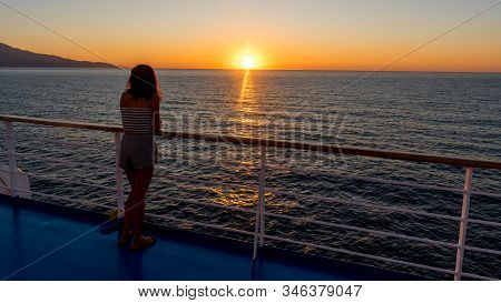 Asian Teen In Tube Top Standing On Deck Of Ferry Looking At Sunset On Ferry To Lesvos