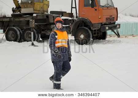 Slinger In An Orange Helmet Walks Down The Assembly Site