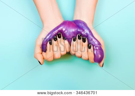 Hands With Holding Slime In Purple Color On Blue Background