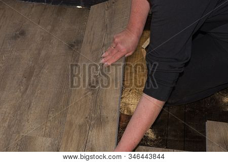 Laying Laminate Or Parquet In The Room, Worker Laying Wood Or Linoleum Laminate On The Floor And Mar