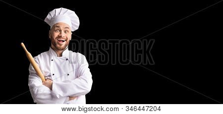 Bakerman. Excited Baker Chef Posing With Dough Rolling Pin Standing Over Black Studio Background. Pa