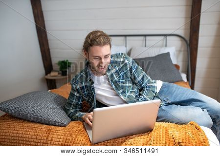 Man Texting On Intrnet While Staying In The Bedroom