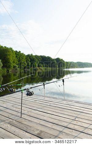 Carp Fishing On Beautiful Blue Lake With Carp Rods And Rod Pods In The Summer Morning. Fishing From 