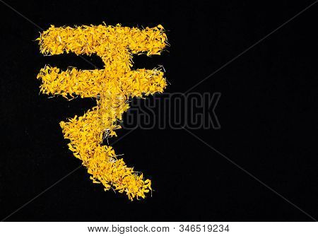 Top View Of Rupee Sign Made By Flower Petals Over The Black Background. Money Concept