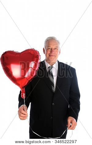 Valentines Day. Red Helium Heart Shape Balloon. A man in a suit holds a Red Heart Shaped Helium Balloon. Isolated on white. Room for text. Clipping Path.  Balloons are loved world wide. 
