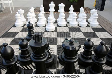 Chess Kit. Giant Chess Game in a public area. People can play a Giant Chess Game as they enjoy a nice day outside. Chess is a game that has been enjoyed for hundreds of years.