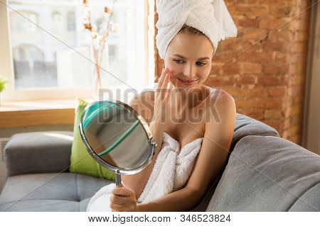 Beauty Day. Woman Wearing Towel Doing Her Daily Skincare Routine At Home. Putting On Moisturizing An