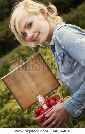 Krásná blonďatá žena sběr jahod