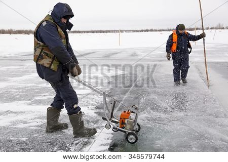 Worker Cuts Out Ice Blocks In Size On The Ice Of A Frozen Lake