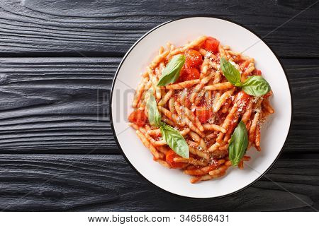 Pasta Trofie Recipe With Tomato Sauce, Parmesan And Basil Close-up In A Plate. Horizontal Top View