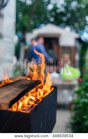 B-b-q Outdoors Background. Kindling Wood Barbecue Outdoors With Open Flame Against The Background Of