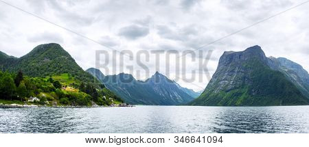 Panorama of dramatic evening view of Hjorundfjorden fjord near Urke village, Norway. Landscape photography