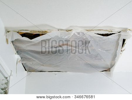 Closeup On Collapsed Ceiling Panel Due To Water Leak Covered With A Sheet Of Plastic - Quick Dirt Fi