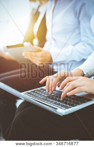 Group Of Diverse Business People Working In Sunny Office, Close-up. Woman Typing On Laptop Computer.
