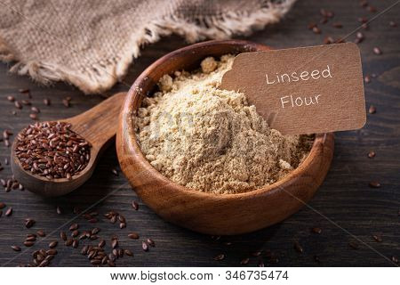 Linseed flour  in a wooden bowl isolated on a white background