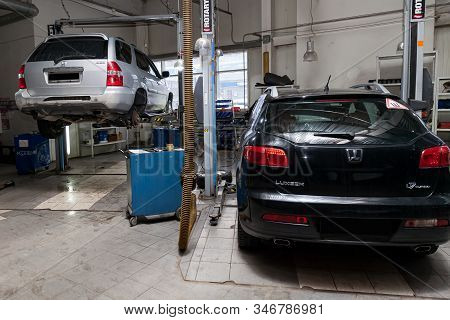 Novosibirsk, Russia - 08.01.2018: Two Used Cars Acura Mdx And Luxgen Raised On A Lift For Repairing 