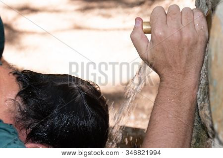 Man's Hand Tightening Water Tap On Head Outdoors