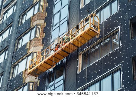 Suspended Construction Craddle Near Wall Of Hightower Residentaial Building With Insulation And Vent