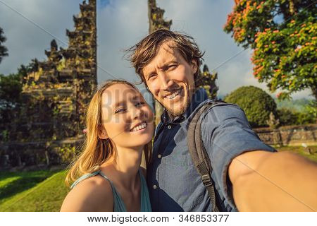 Woman And Man Tourists Walking Through Traditional Balinese Hindu Gate Candi Bentar Close To Bedugul