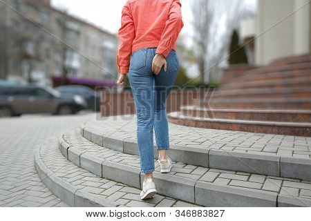 Woman Suffering From Hemorrhoid Pain Outdoors, Back View