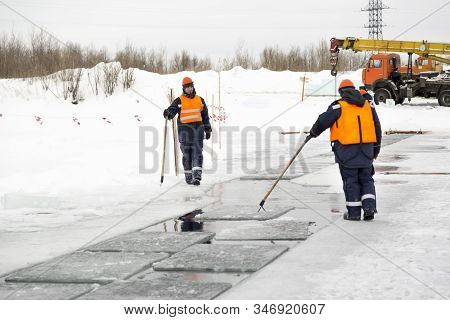 Installers In Life Jackets Rafting Ice Panels To The Lane With The Beograms