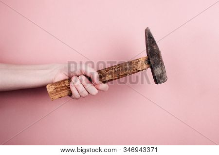 Female Hand Holding Rusty Hammer On Colorful Trendy Pink Background. Gender-neutral And Unisex Job C