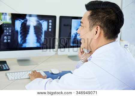 Professional Pulmonologist Giving Call To His Colleague To Ask For Advice While Looking To X-ray Ima