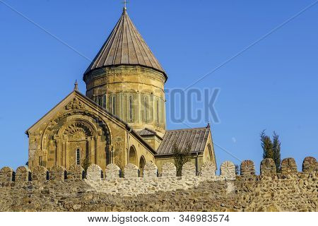 Svetitskhoveli Cathedral, Mtskheta, Georgia. The Dome Of The Cathedral Above The Battlements Against