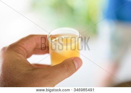 shot orange cocktail in hand
