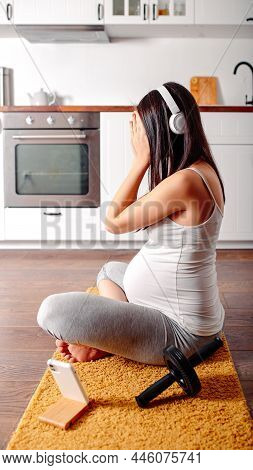 Pregnant Doing Workout On Orange Fitness Mat. Pragnant Yoga At Home In The Kitchen. Pregnant In Whit